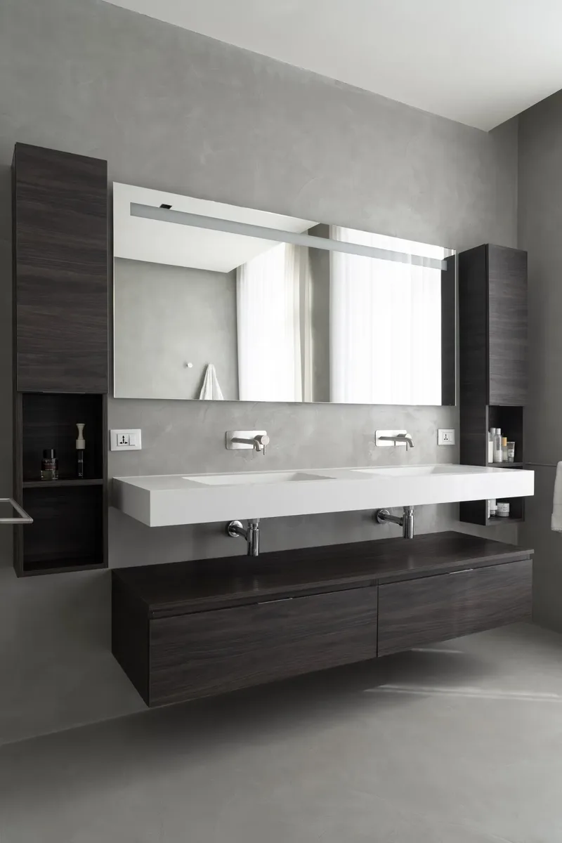 Mueble ancho 180cm, profundidad 46 cm, frentes y cuerpo en Melamina olmo lava. Espejo rectangular con iluminación frontal, también disponible con retroiluminación en los 4 lados y sensor táctil lateral en la parte inferior derecha; grosor: 2 cm.