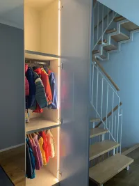 Customized wardrobe: this entrance wardrobe, installed in our client’s home in Königstein, Germany, combines practicality with style. Featuring a mirrored door in the center, it offers the perfect solution for a quick check before heading out. Conveniently positioned at the entrance, the mirror is seamlessly integrated as part of the wardrobe, making it both space-saving and effortlessly functional. The other doors are matte lacquered in RAL 7001 with integrated handles R which is finished in the same color as the doors. The interior features side LED lights and hanging rods finished in RAL 8019.

The exact measurements of this wardrobe are 161 cm in width, 262 cm in height, and 61 cm in depth.