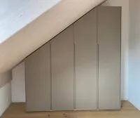 Sloping roof wardrobe: every roof has a different slope, so we offer our configurator, which adapts perfectly to your measurements to create a practical and functional wardrobe design customized to your needs. Everything is neatly enclosed behind personalized color doors. 
This wardrobe is installed in our customer’s house in Watt, Switzerland - FB 243 Charleston Gray matte lacquered with integrated handles.