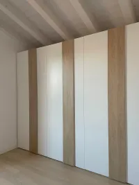 Fitted wardrobe: a white wardrobe with laminate handles in a warm light honey color, perfectly complementing the wooden floor and sloped wooden ceiling, while adding brightness to our client&rsquo;s bedroom in Padua, Italy – RAL9003 matte lacquered with handle K Rovere.

The exact measurements of this wardrobe are 277 cm in width, 246 cm in height, and 61 cm in depth.

